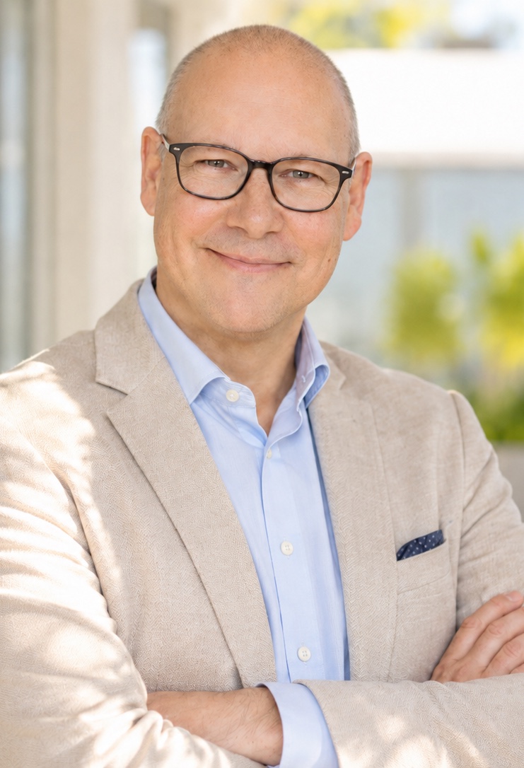 Lars Winter im hellen Sakko mit verschränkten Armen